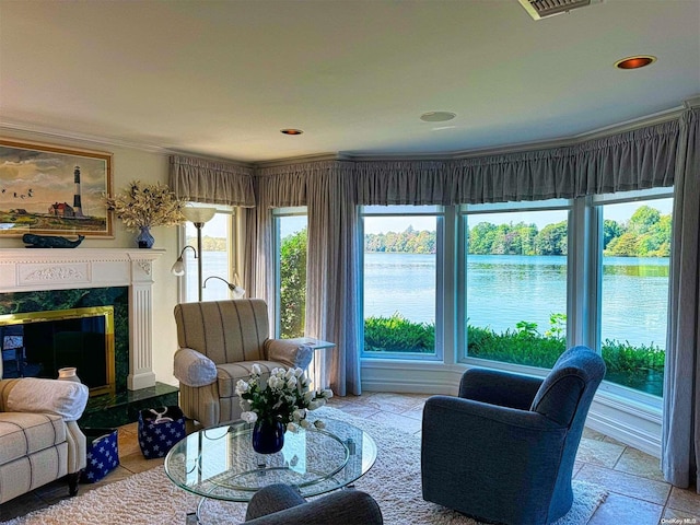 living room featuring a water view, ornamental molding, and a fireplace