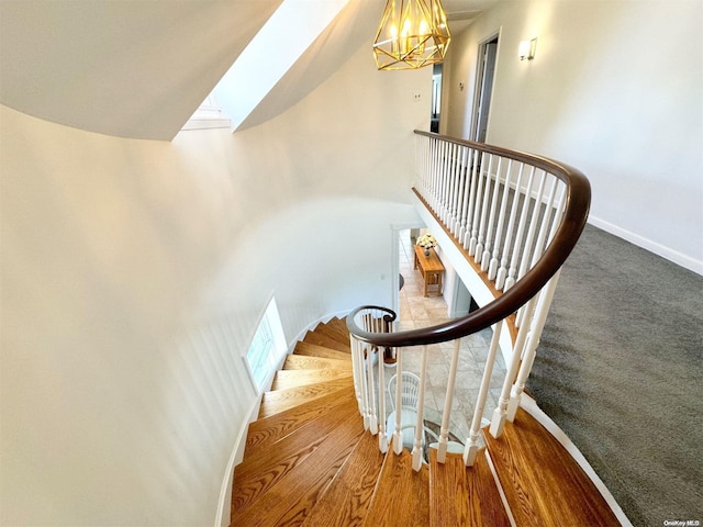 stairs with a chandelier and wood-type flooring