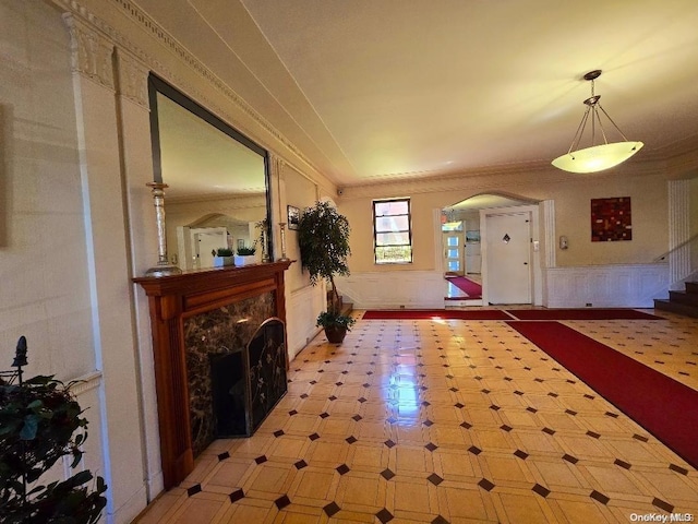 foyer entrance featuring a high end fireplace and ornamental molding