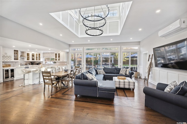 living room featuring an inviting chandelier, sink, wine cooler, a wall mounted AC, and dark hardwood / wood-style flooring