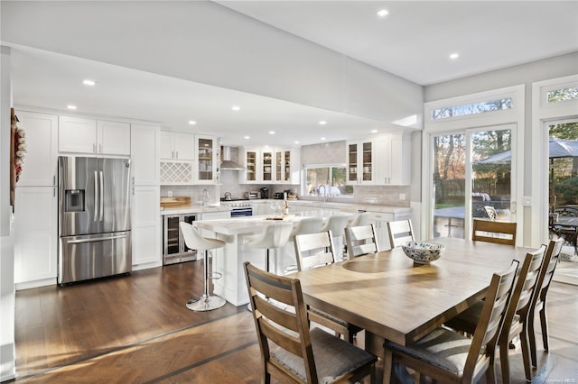 dining room with dark hardwood / wood-style floors, sink, and beverage cooler