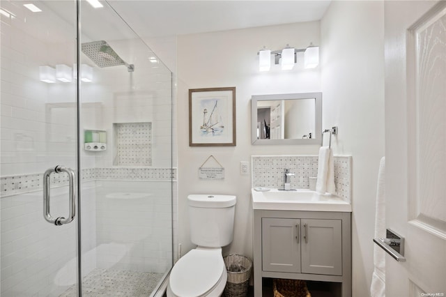 bathroom with vanity, toilet, and a shower with door