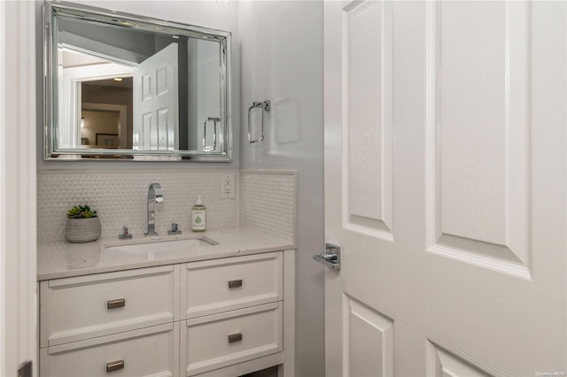 bathroom featuring vanity and tasteful backsplash