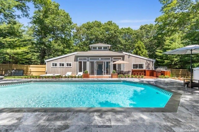 view of swimming pool featuring exterior bar and a patio