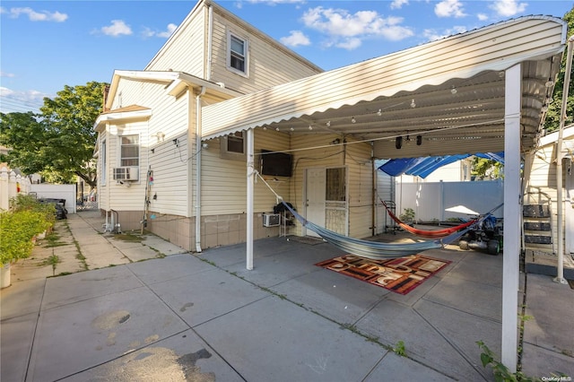 rear view of property featuring cooling unit and a carport