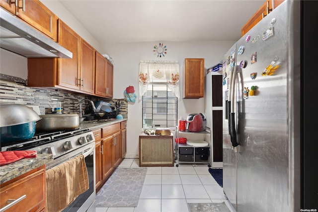 kitchen with light tile patterned floors, backsplash, stainless steel appliances, and sink