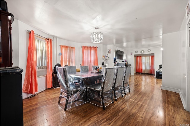 dining room with wood-type flooring and an inviting chandelier