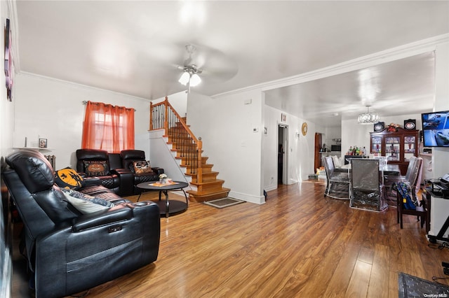 living room featuring ceiling fan with notable chandelier, hardwood / wood-style flooring, and ornamental molding