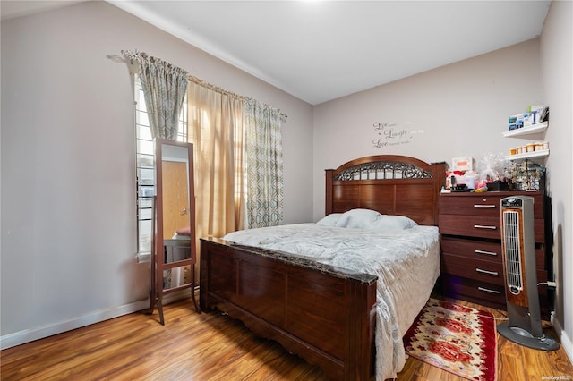 bedroom with lofted ceiling and light wood-type flooring