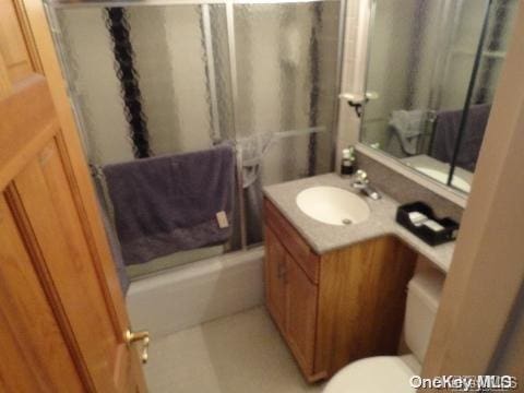 full bathroom featuring vanity, toilet, and combined bath / shower with glass door