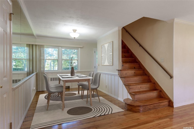 dining area featuring a textured ceiling, light hardwood / wood-style floors, and crown molding