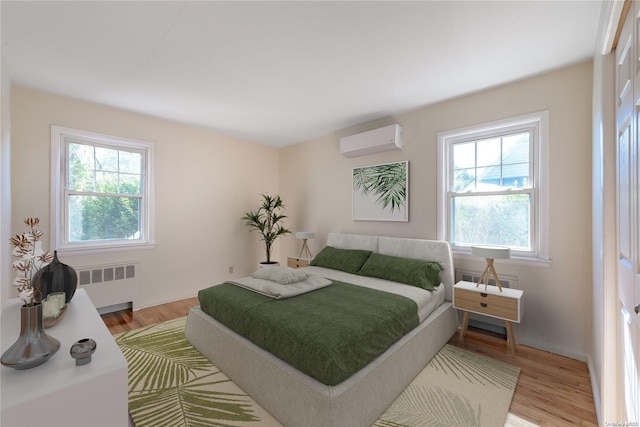 bedroom featuring multiple windows, a wall mounted air conditioner, light hardwood / wood-style flooring, and radiator