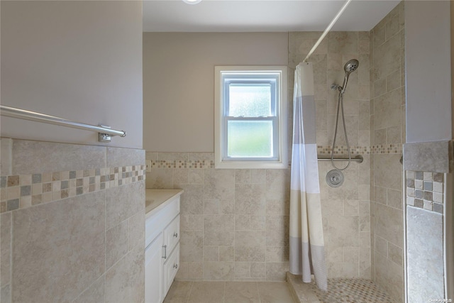 bathroom featuring tile patterned flooring, a shower with curtain, vanity, and tile walls