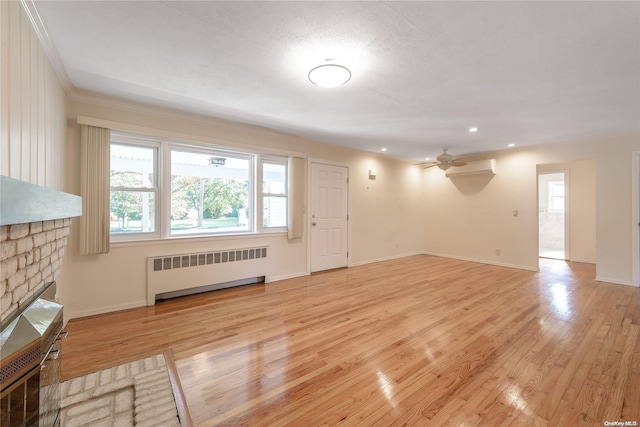 unfurnished living room featuring radiator heating unit, light hardwood / wood-style flooring, ceiling fan, and crown molding