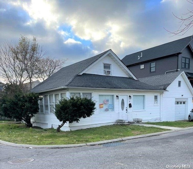 view of front of property with a front yard and a garage