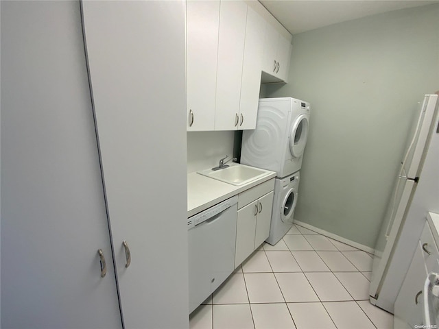 washroom featuring sink, light tile patterned floors, and stacked washer / dryer