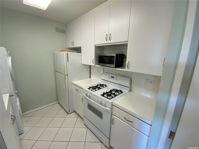 kitchen with white cabinets, white appliances, and light tile patterned flooring