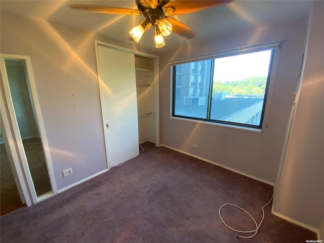 unfurnished bedroom featuring ceiling fan, a closet, and dark carpet