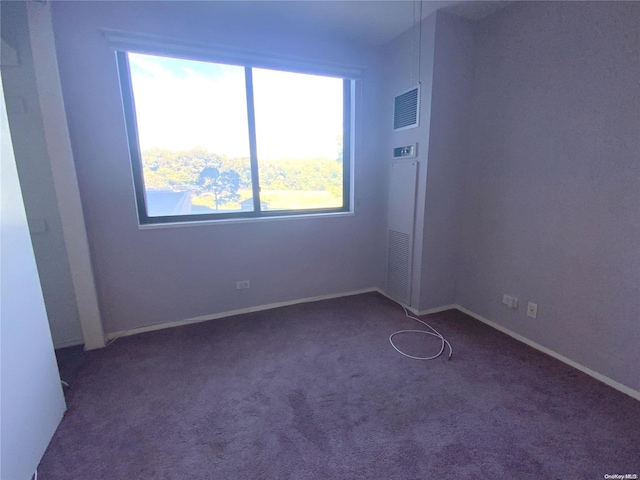 unfurnished room featuring dark colored carpet