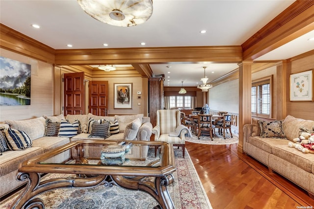 living room featuring hardwood / wood-style floors, crown molding, and decorative columns