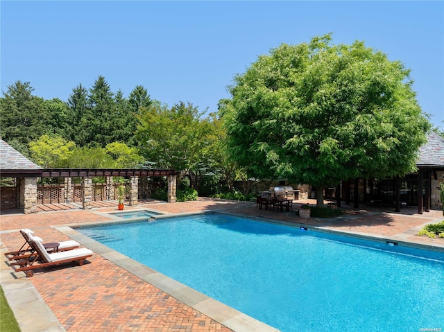 view of swimming pool with an in ground hot tub and a patio area