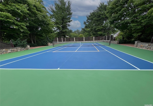 view of tennis court featuring basketball hoop