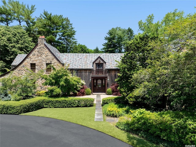 english style home featuring a front yard