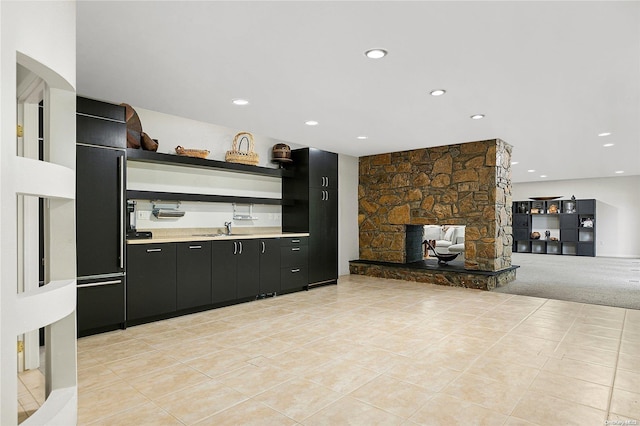 kitchen featuring a fireplace, light tile patterned floors, and sink