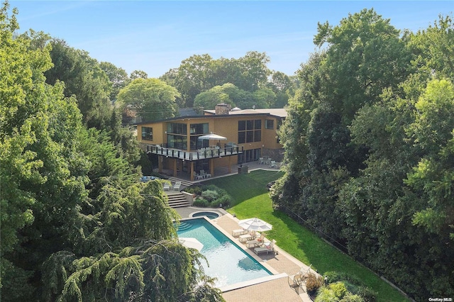 exterior space featuring a lawn, a patio area, and a balcony