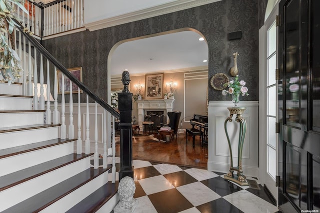 1974 Monroe Ave, North Bellmore, NY 11710 - entrance foyer with wallpapered walls, arched walkways, a fireplace, a decorative wall, and stairway