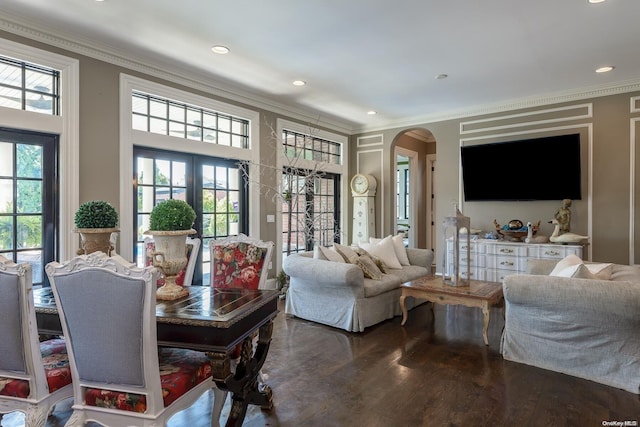 living room featuring dark hardwood / wood-style floors, a wealth of natural light, and ornamental molding