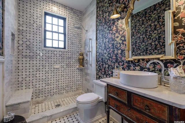 bathroom with tile patterned flooring, a tile shower, vanity, and toilet