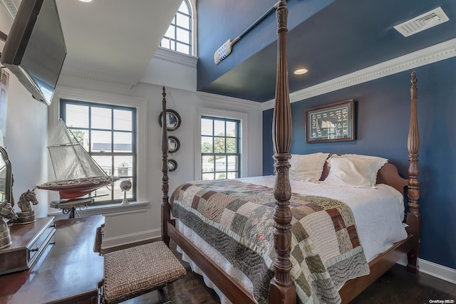 bedroom with multiple windows, crown molding, and dark wood-type flooring