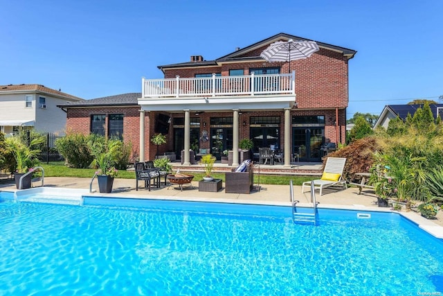 1974 Monroe Ave, North Bellmore, NY 11710 - rear view of house with a balcony, brick siding, a patio area, and an outdoor pool