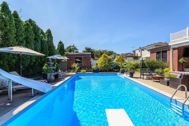 1974 Monroe Ave, North Bellmore, NY 11710 - view of swimming pool with a water slide, a diving board, a patio area, and an outdoor structure