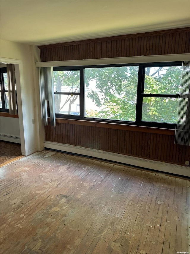 spare room featuring wood-type flooring and baseboard heating