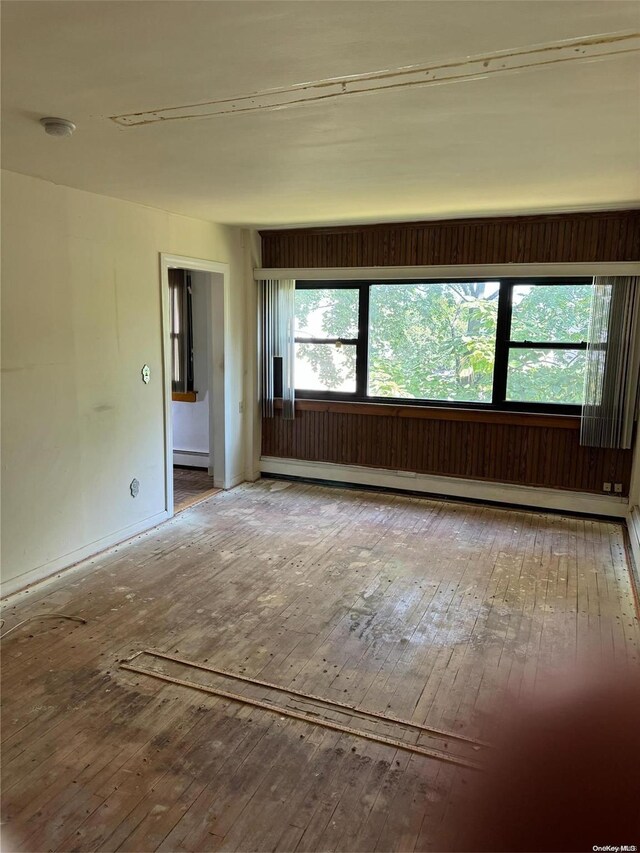 spare room featuring hardwood / wood-style floors and a baseboard heating unit