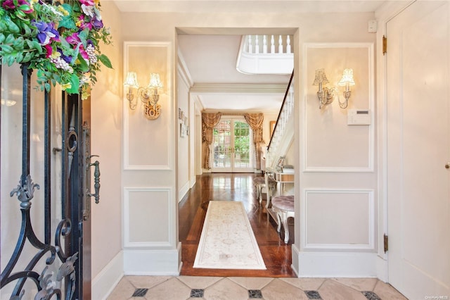 entryway with wood-type flooring and ornamental molding