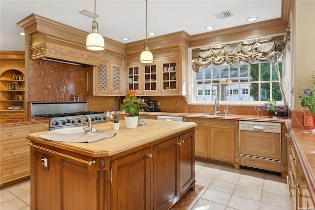 kitchen featuring stainless steel appliances, a kitchen island with sink, crown molding, light tile patterned floors, and hanging light fixtures