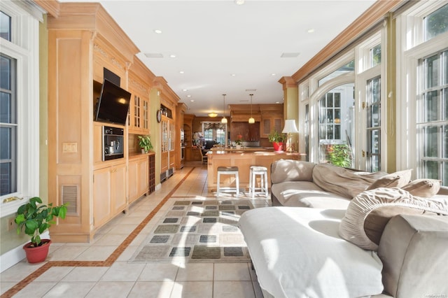 living room featuring plenty of natural light, light tile patterned flooring, and ornamental molding