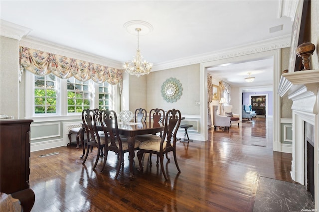 dining room featuring dark hardwood / wood-style flooring, an inviting chandelier, and crown molding