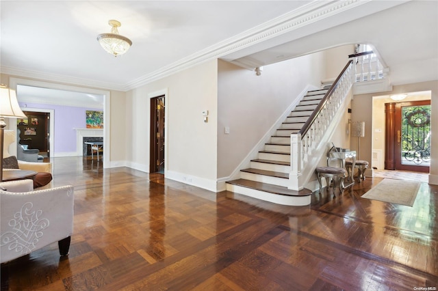 entrance foyer with dark parquet flooring, a fireplace, and ornamental molding