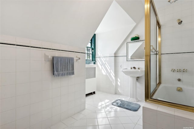 bathroom with tile patterned floors, tiled shower / bath combo, and tile walls