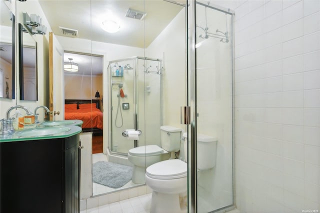 bathroom featuring tile patterned flooring, vanity, toilet, and walk in shower