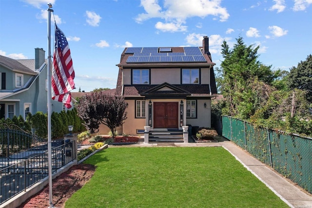 view of front of property with a front yard and solar panels