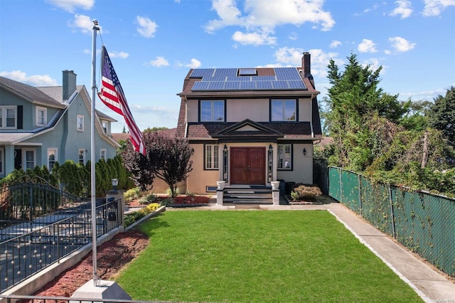 view of front property featuring a front yard and solar panels