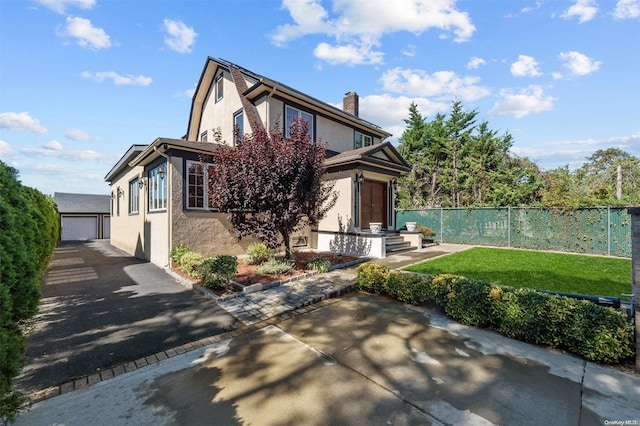 view of front of home featuring a garage, an outbuilding, and a front yard