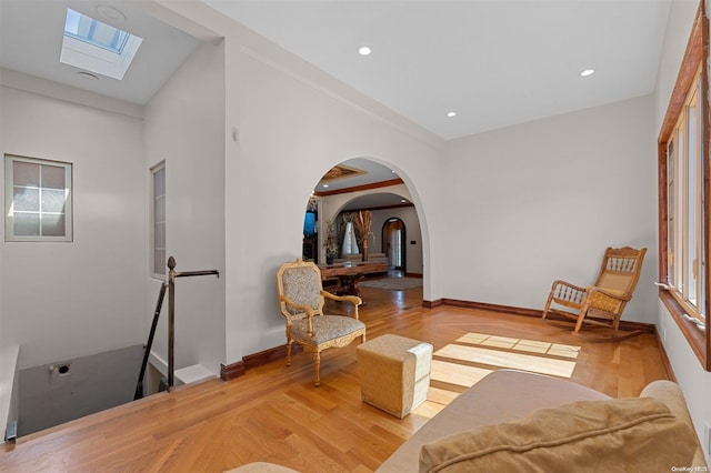 living area featuring hardwood / wood-style floors and a skylight