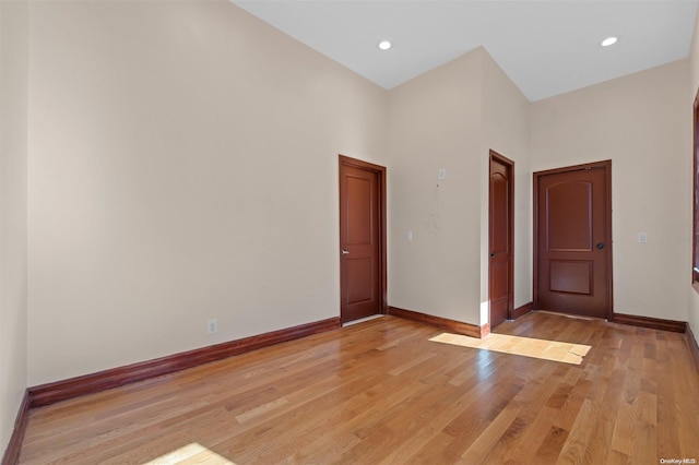 unfurnished room with a high ceiling and light hardwood / wood-style flooring