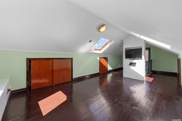 bonus room with dark hardwood / wood-style floors and lofted ceiling with skylight